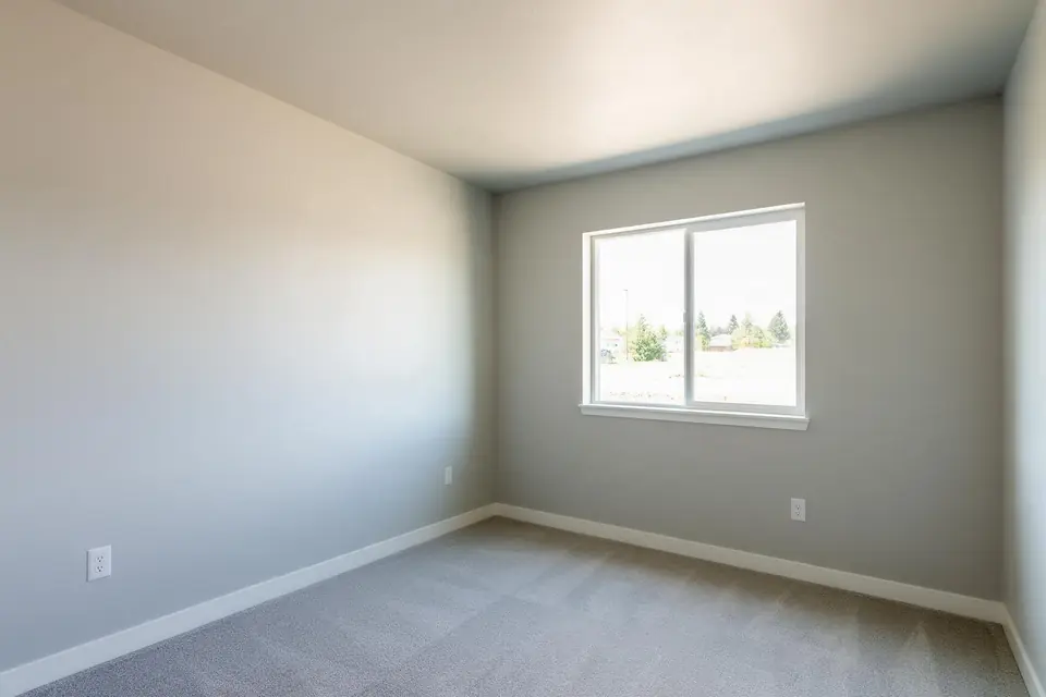 An empty rental bedroom freshly repainted in light gray
